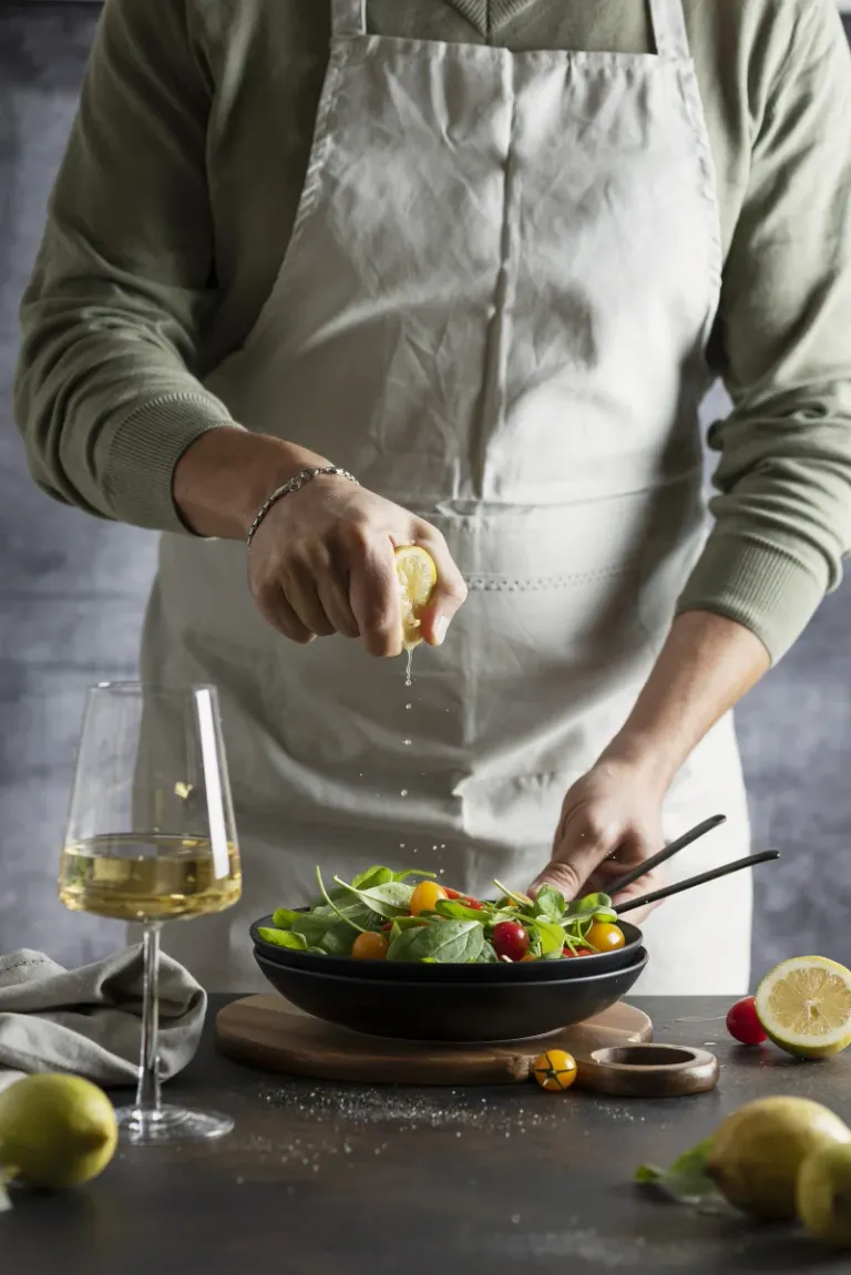 man squeezing out lemon healthy green salad with red yellow tomatoes selective focus image